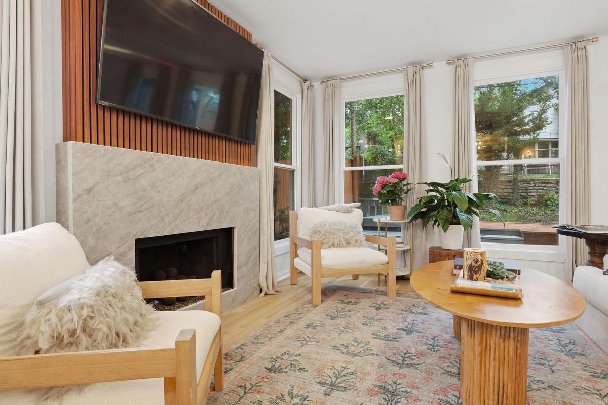 Sunlit living room with a fireplace and tall windows
