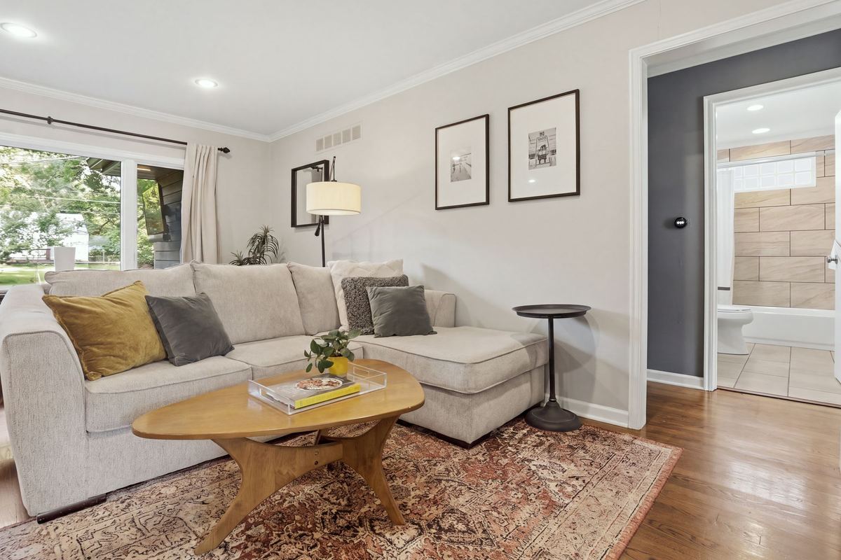 Living room with a sectional sofa, round coffee table and gallery wall