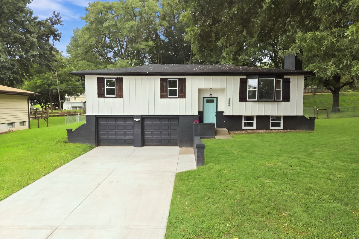 White and black home with a teal front door