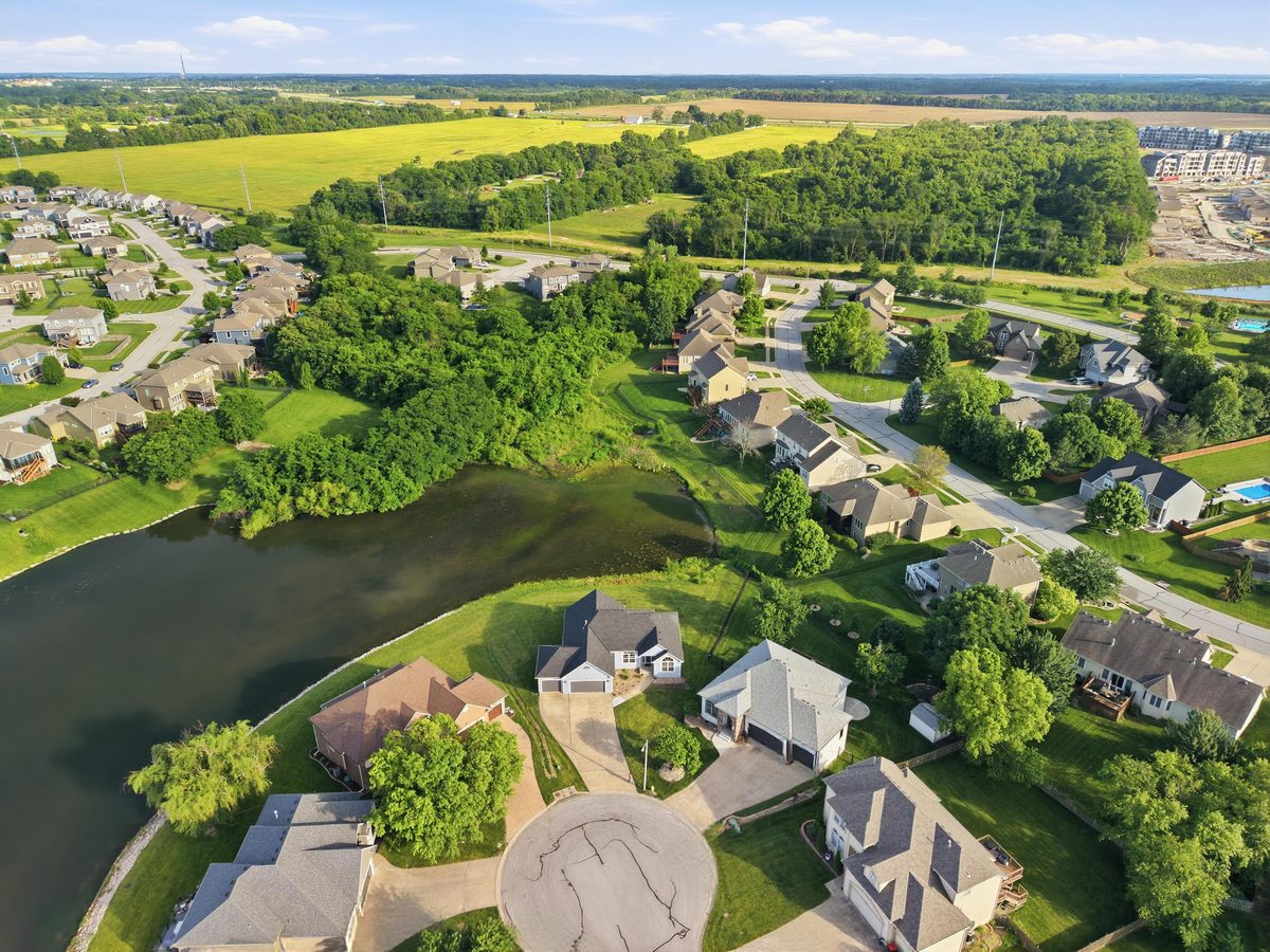 Drone photo showing a home, the pond and the surrounding neighborhood
